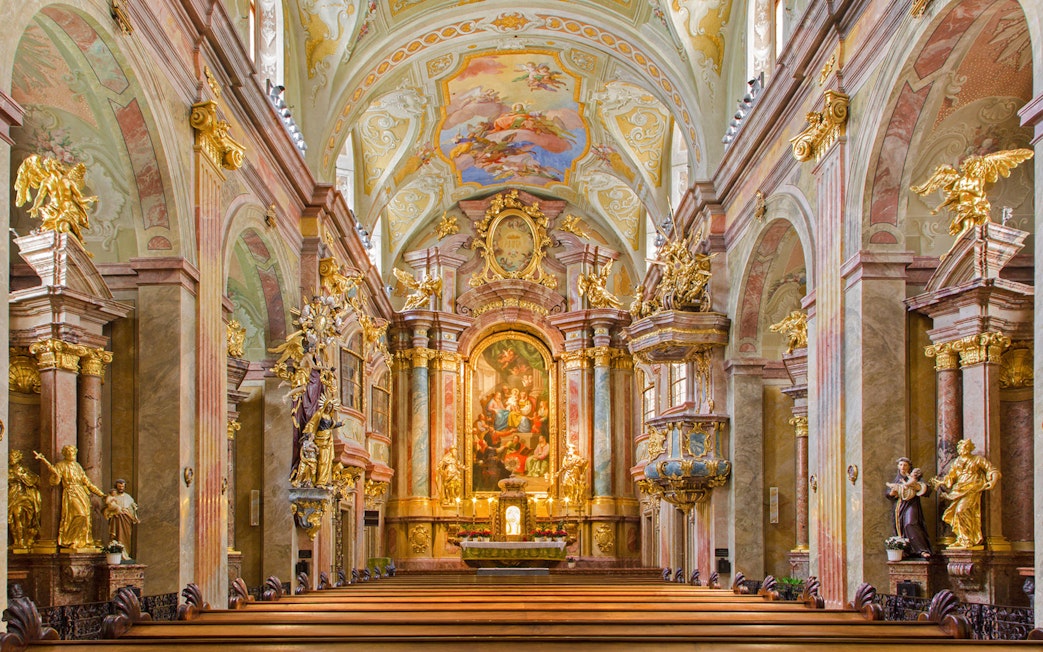 Interior of St Anne's Church with ornate altar and detailed frescoes.