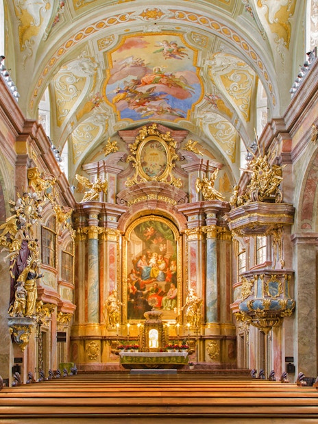 Interior of St Anne's Church with ornate altar and detailed frescoes.