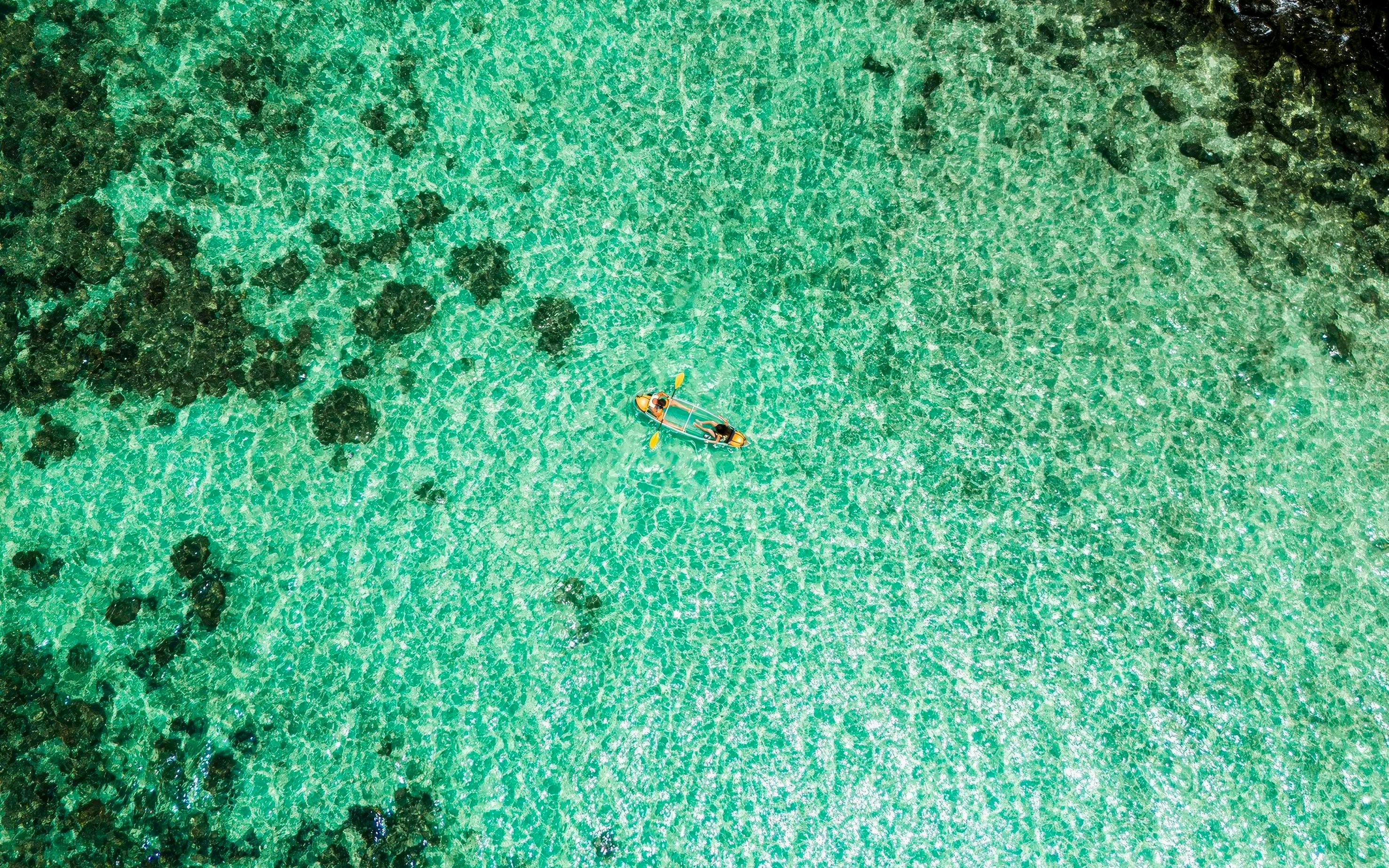 Canoeing on clear turquoise waters at Banana Beach, Koh Hey.