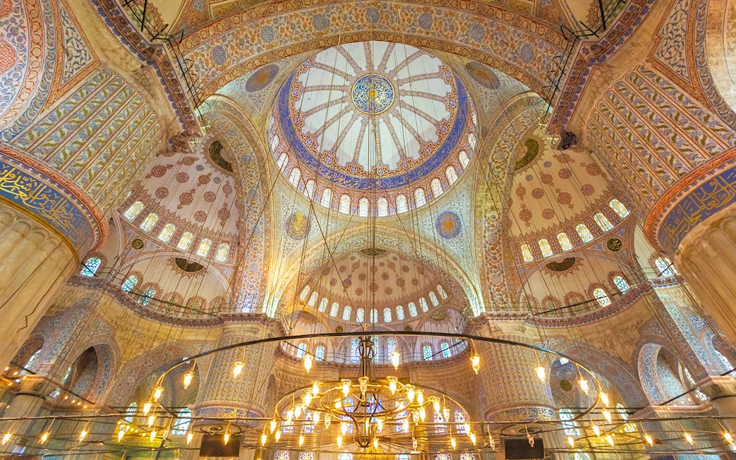 Blue Mosque interior with ornate domes and intricate patterns, Istanbul.