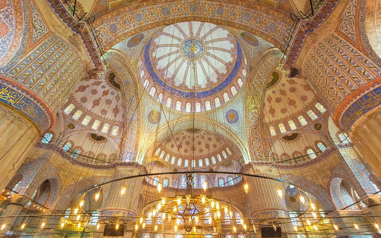 Blue Mosque interior with ornate domes and intricate patterns, Istanbul.