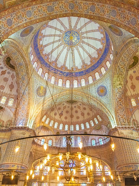 Blue Mosque interior with ornate domes and intricate patterns, Istanbul.