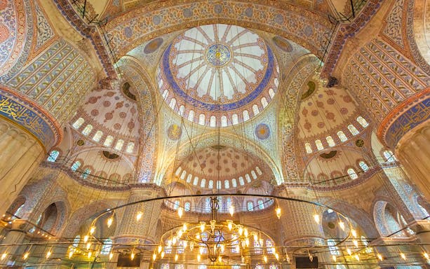 Blue Mosque interior with ornate domes and intricate patterns, Istanbul.