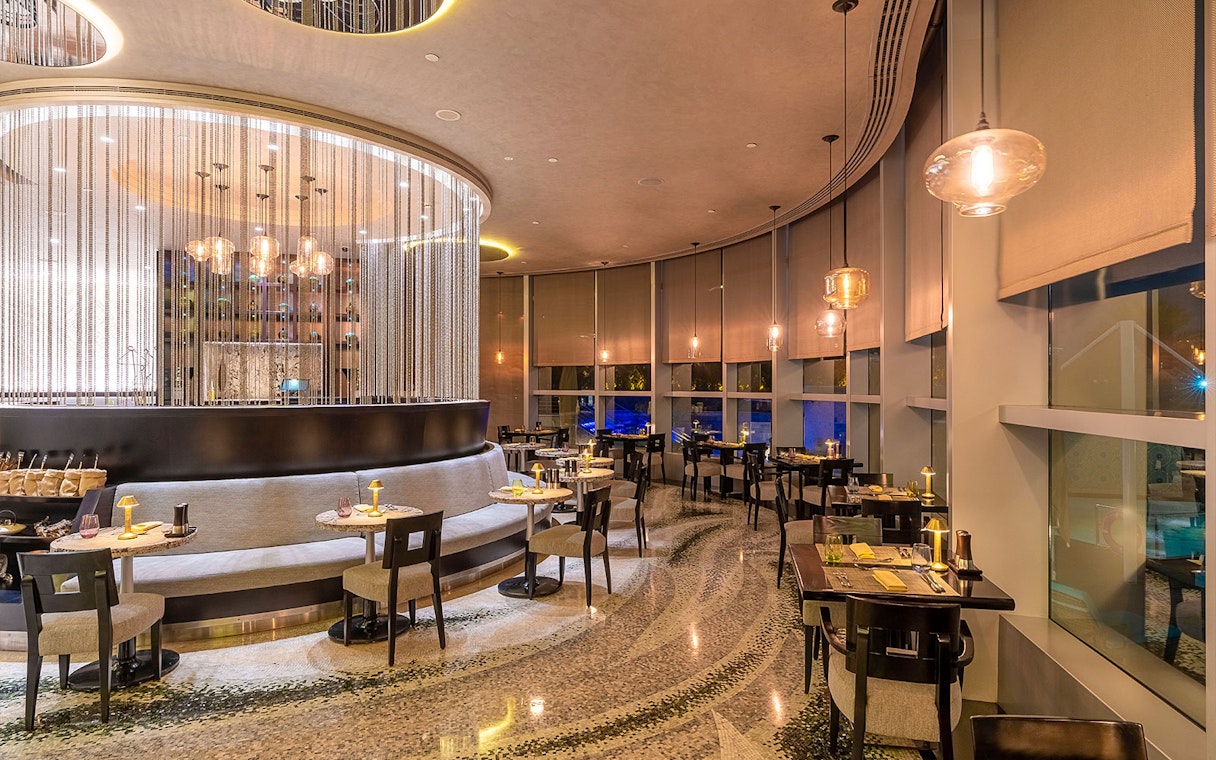 Buffet dining area at Mundo Jumeirah Emirates Towers with elegant seating and ambient lighting.