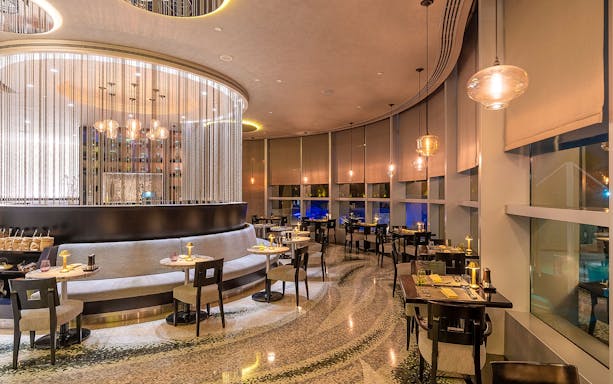 Buffet dining area at Mundo Jumeirah Emirates Towers with elegant seating and ambient lighting.