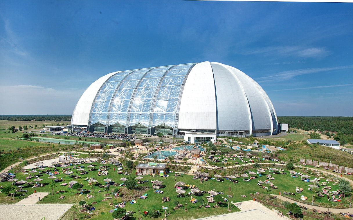 Tropical Islands Resort dome with outdoor pool and sunbathing area in Germany.