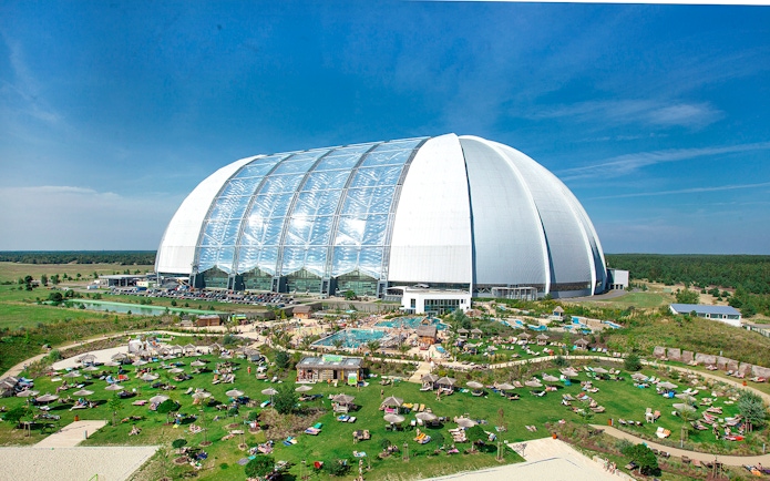 Tropical Islands Resort dome with outdoor pool and sunbathing area in Germany.