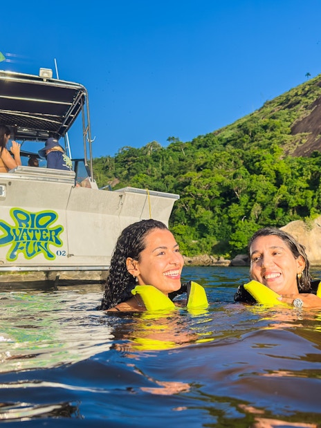 Tourists swimming near a boat in Guanabara Bay, Rio de Janeiro.
