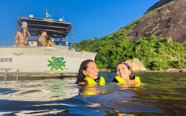Tourists swimming near a boat in Guanabara Bay, Rio de Janeiro.