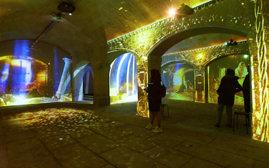 Porto Legends immersive experience with projections and audioguide in a historic stone hall.