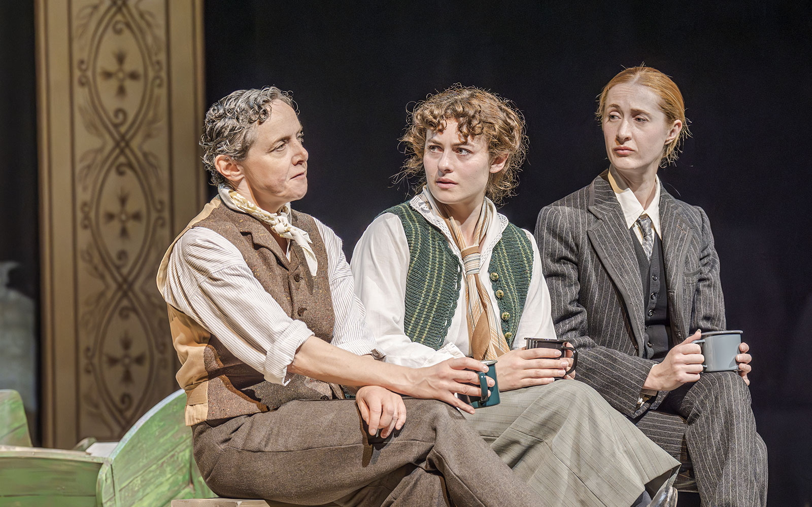 Artists performing in Grace Pervades West End show, seated and holding mugs.