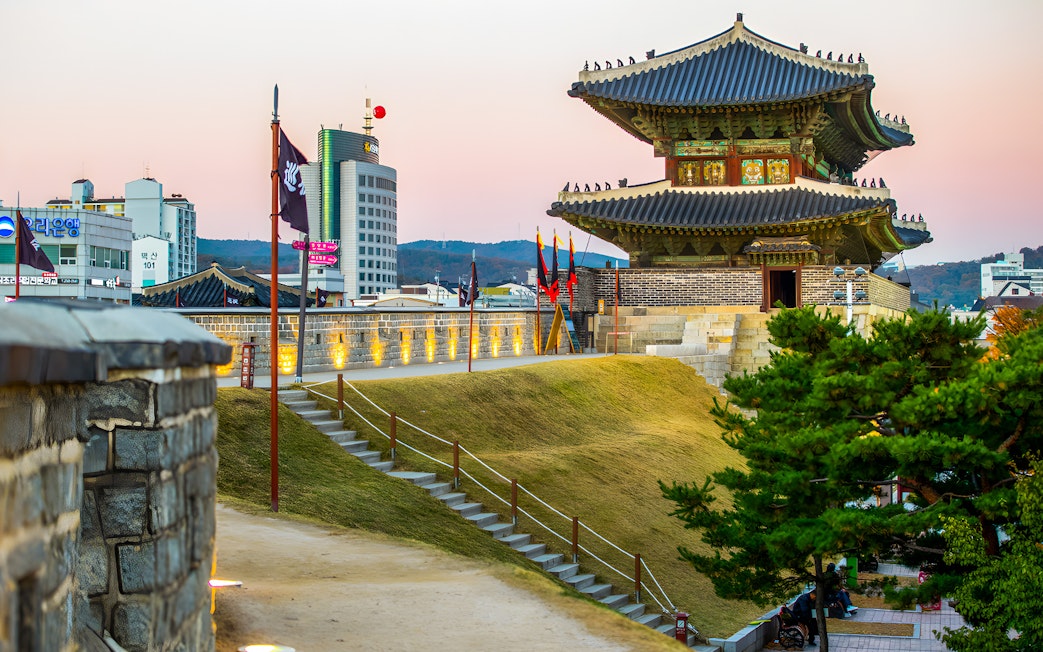 Suwon Hwaseong Fortress wall and watchtower at sunset, South Korea.