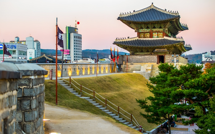 Suwon Hwaseong Fortress wall and watchtower at sunset, South Korea.
