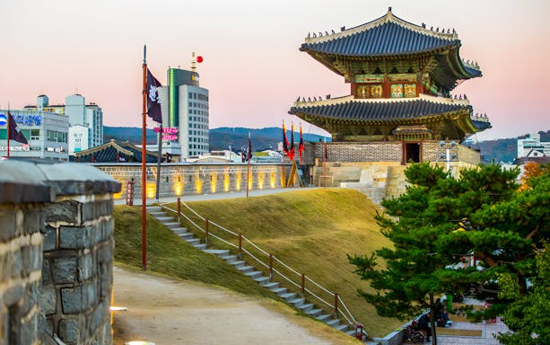 Suwon Hwaseong Fortress wall and watchtower at sunset, South Korea.
