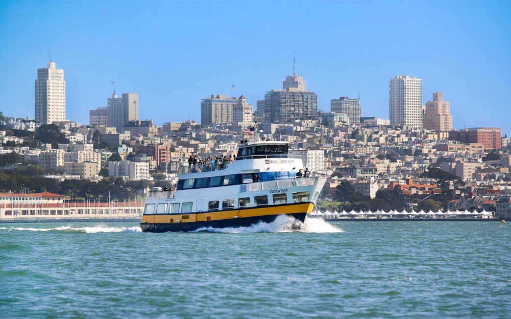 Ferry with guests sailing near San Francisco skyline.
