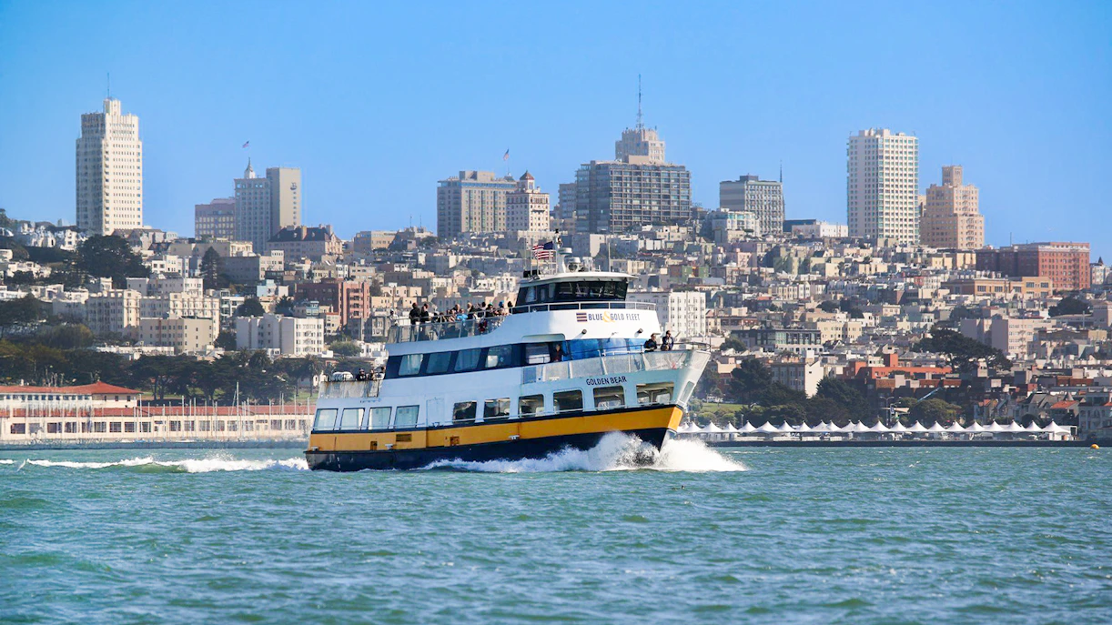 Ferry with guests sailing near San Francisco skyline.
