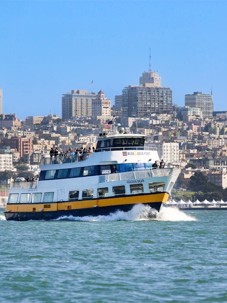 Ferry with guests sailing near San Francisco skyline.