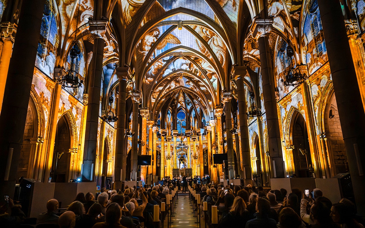 LUMINISCENCE 360° show inside Manchester Cathedral with illuminated arches and audience.