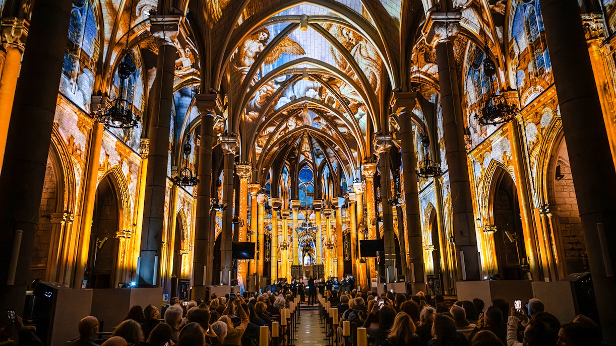 LUMINISCENCE 360° show inside Manchester Cathedral with illuminated arches and audience.