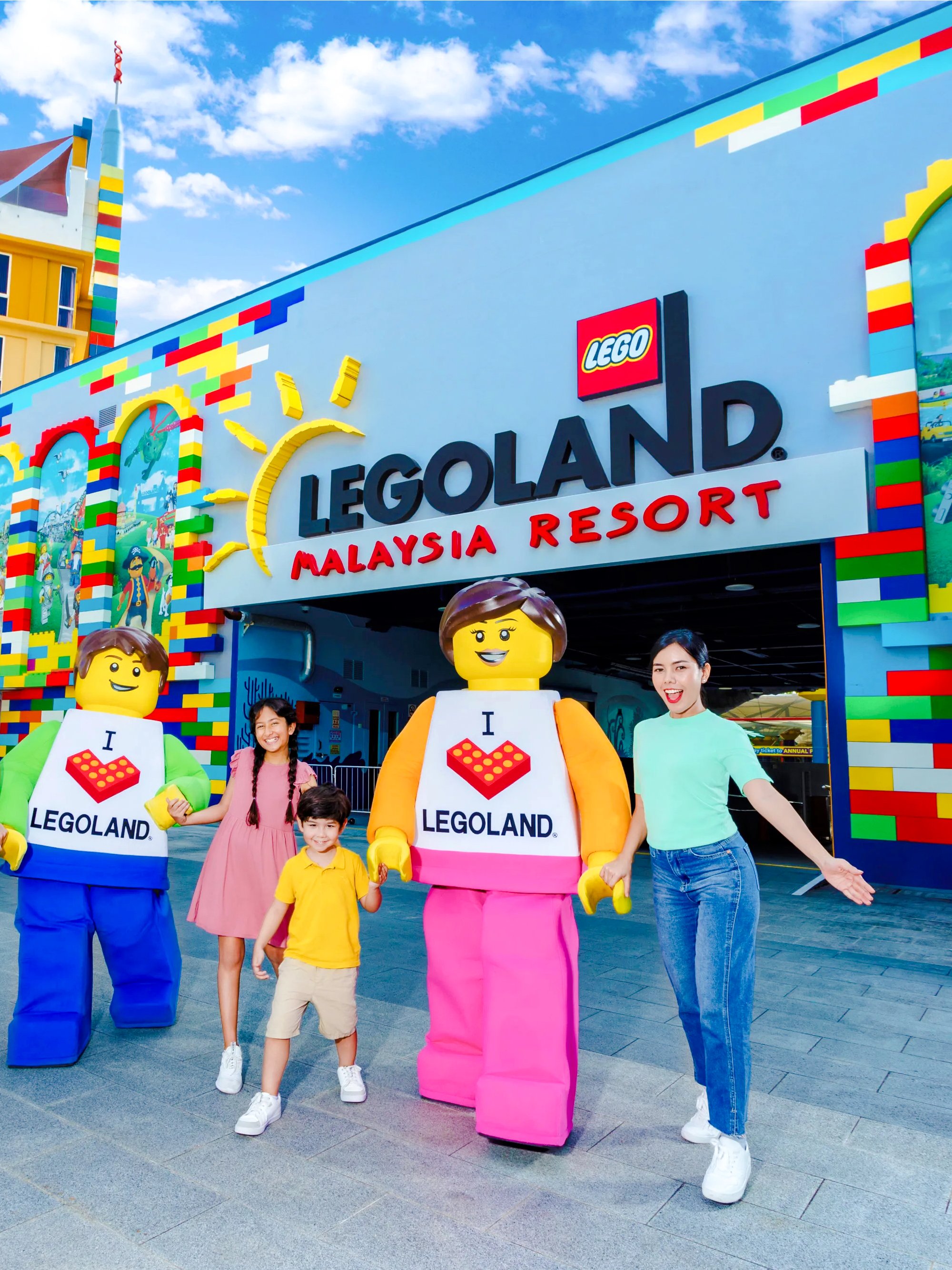 Family at Legoland Malaysia entrance with Lego characters.