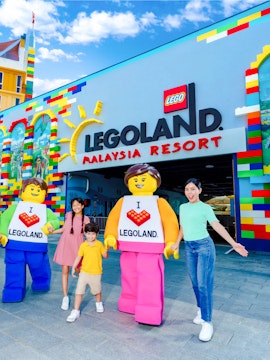 Family at Legoland Malaysia entrance with Lego characters.