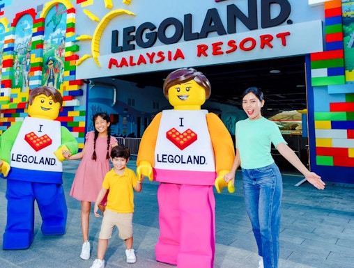 Family at Legoland Malaysia entrance with Lego characters.