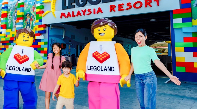 Family at Legoland Malaysia entrance with Lego characters.