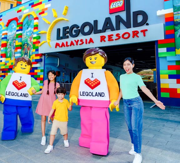 Family at Legoland Malaysia entrance with Lego characters.
