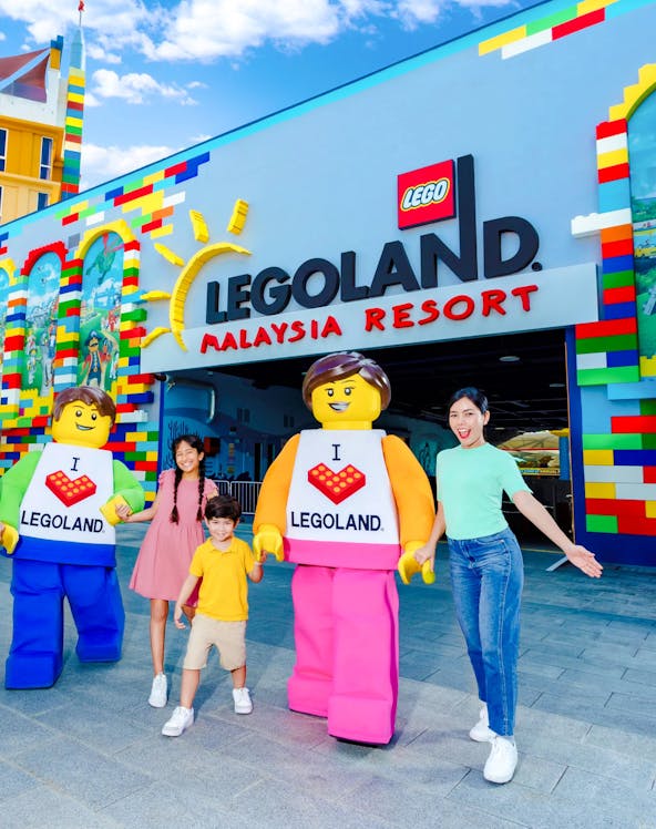 Family at Legoland Malaysia entrance with Lego characters.