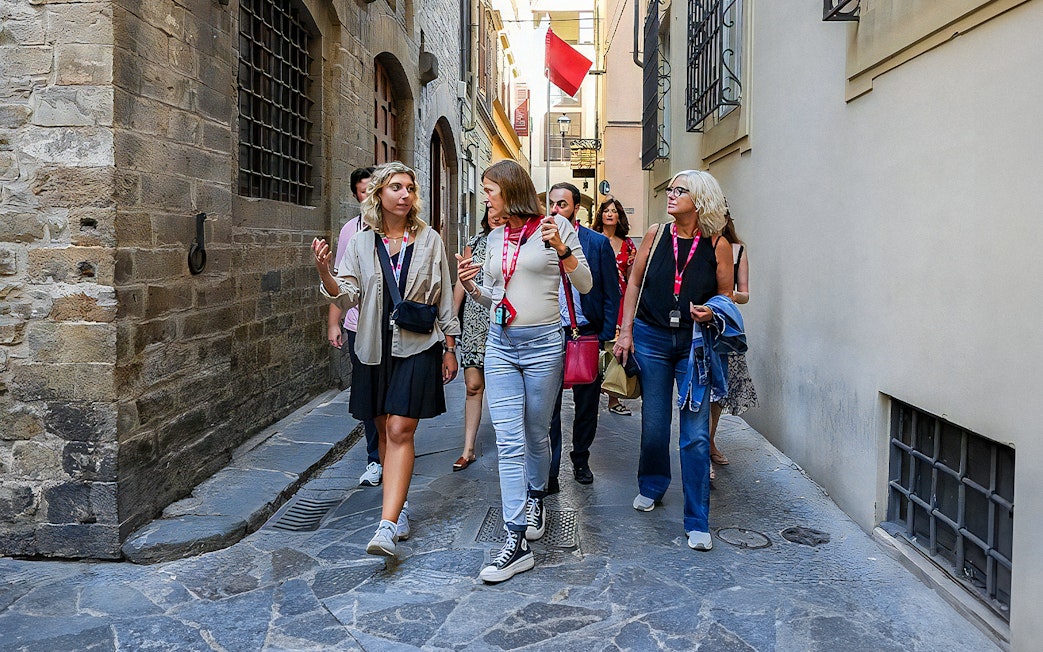 Tour group walking through narrow street in Florence.