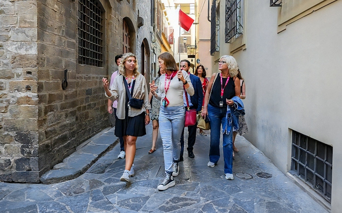 Tour group walking through narrow street in Florence.