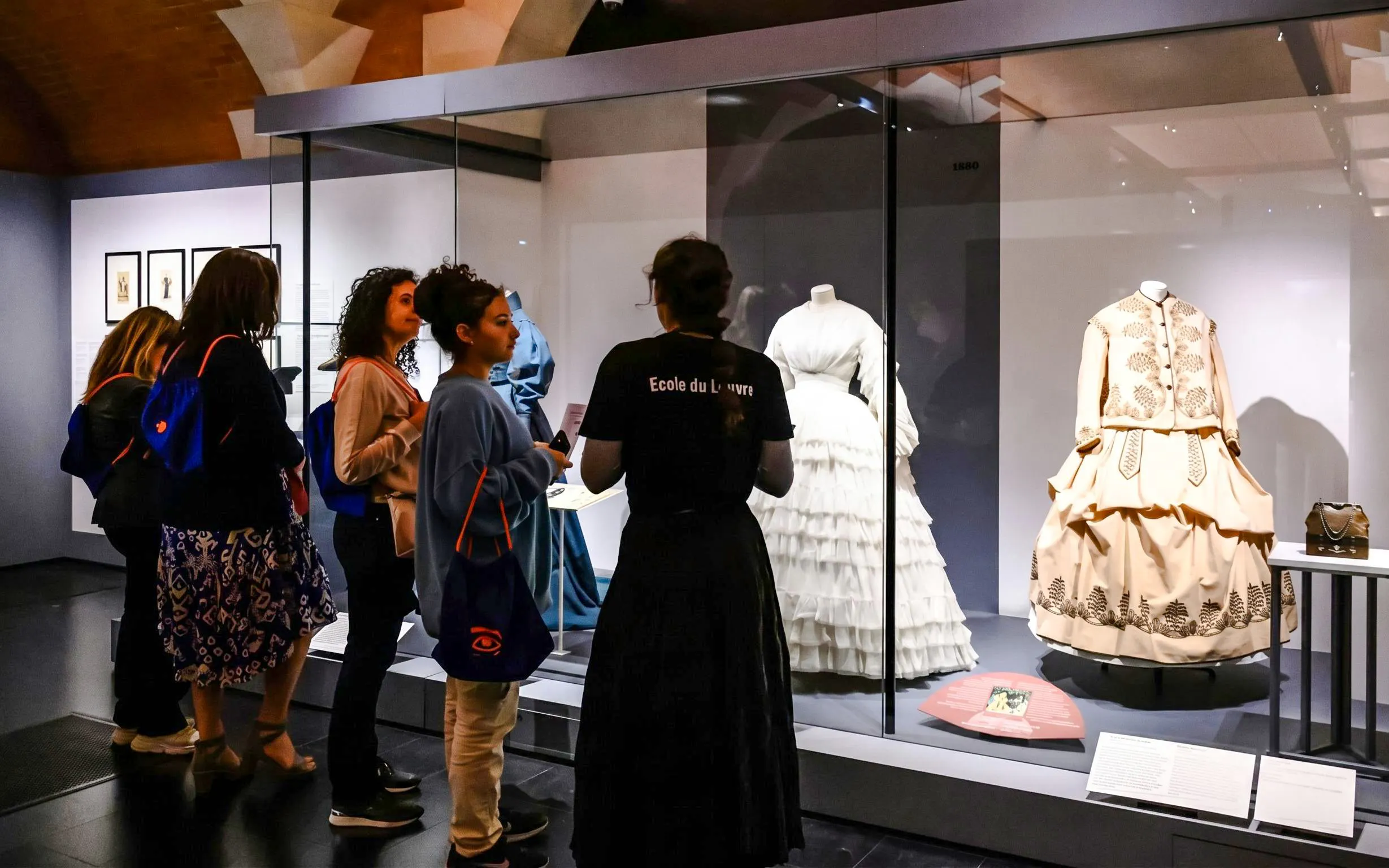 Visitors viewing historical fashion exhibits at Palais Galliera, Paris.