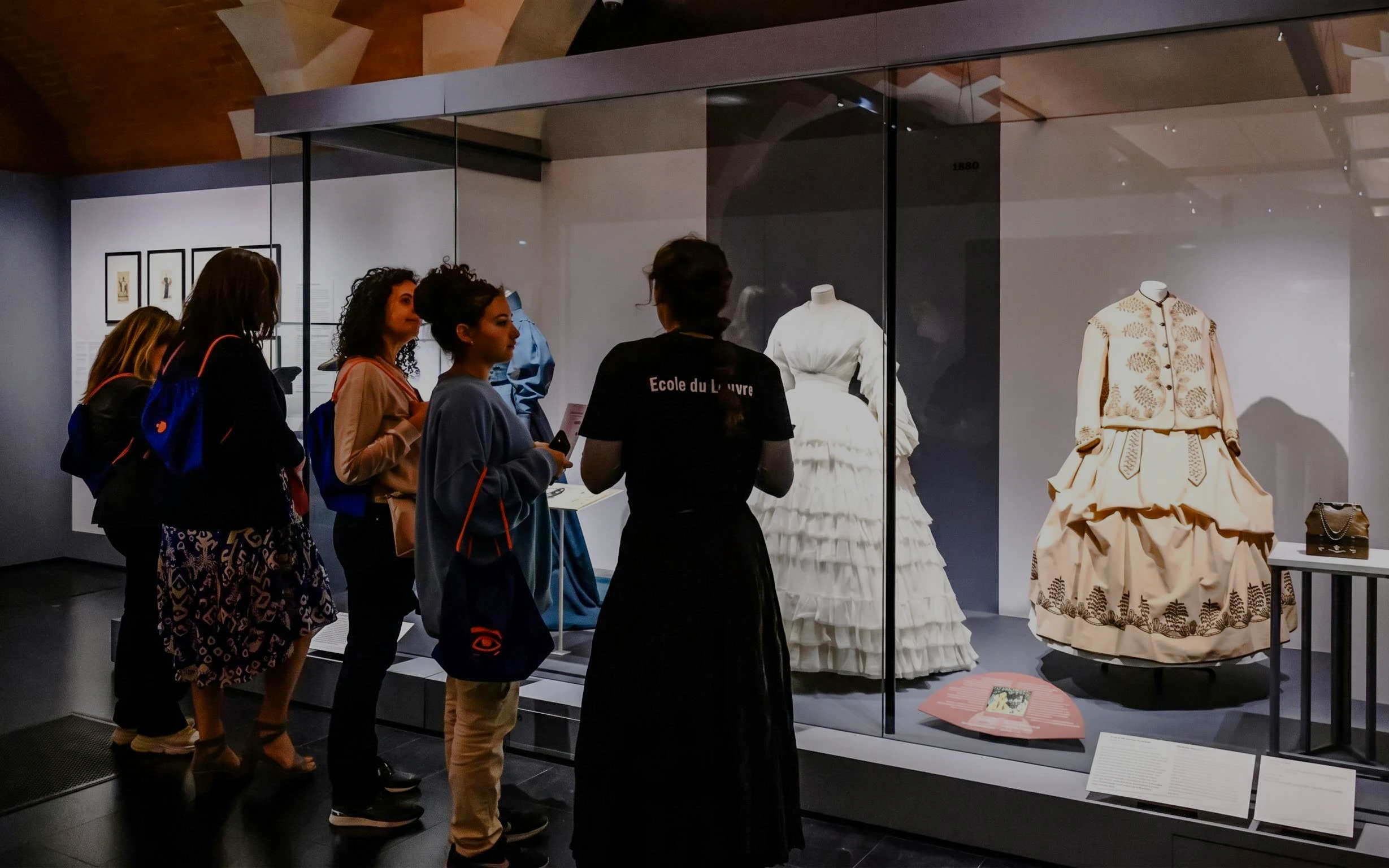Visitors viewing historical fashion exhibits at Palais Galliera, Paris.