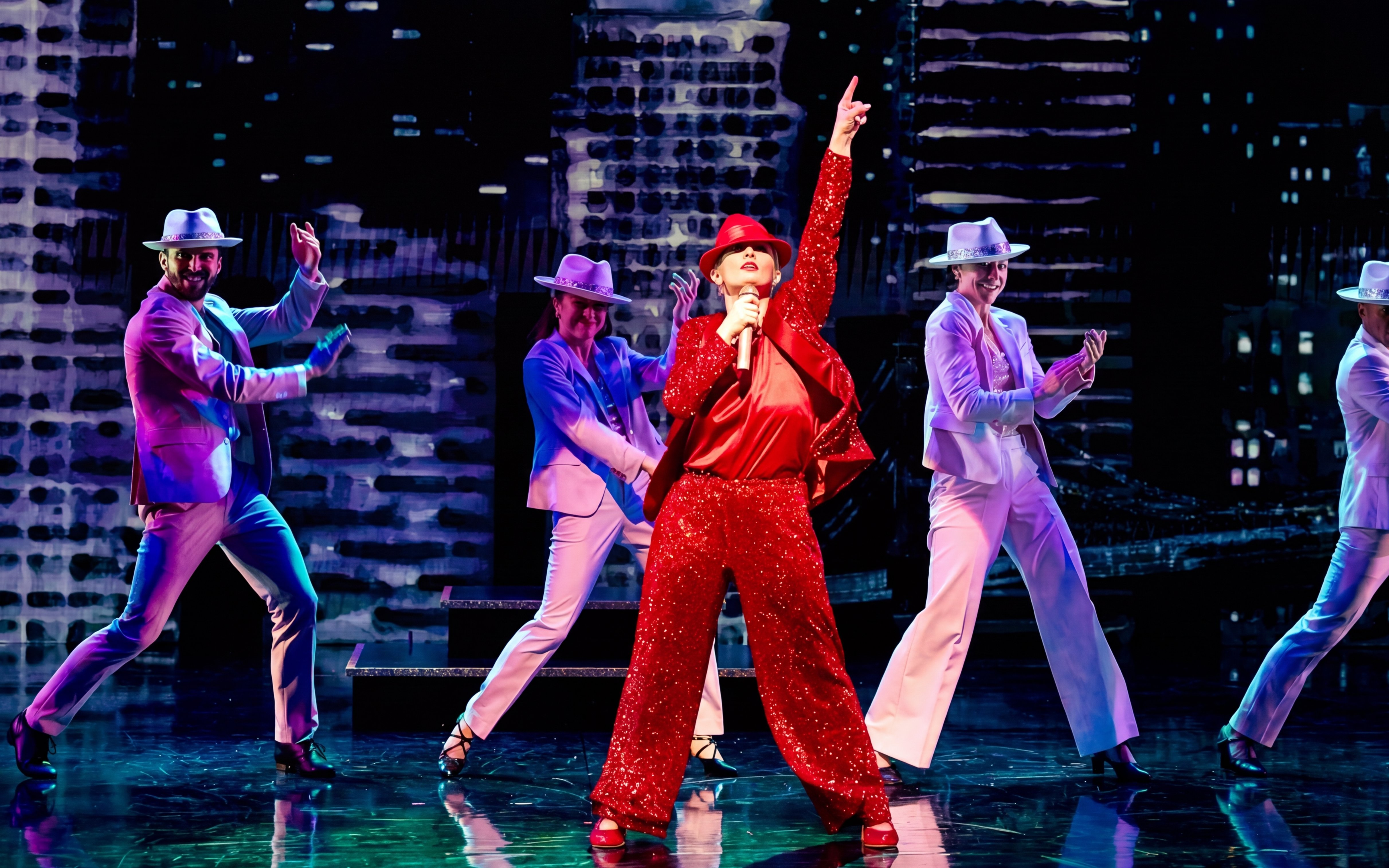 Performers in vibrant costumes dancing energetically on stage during "Gotta Dance!" show.