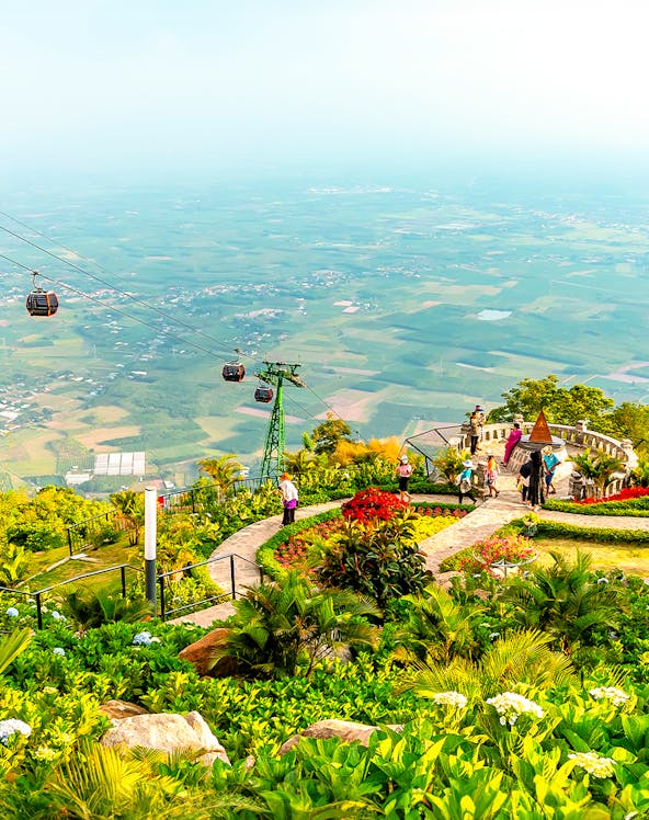 Cable cars over lush gardens at Sun World Ba Den Mountain, Vietnam.