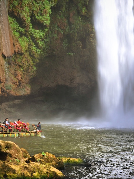 Boat near Ouzoud waterfall in Morocco with tourists enjoying the view.