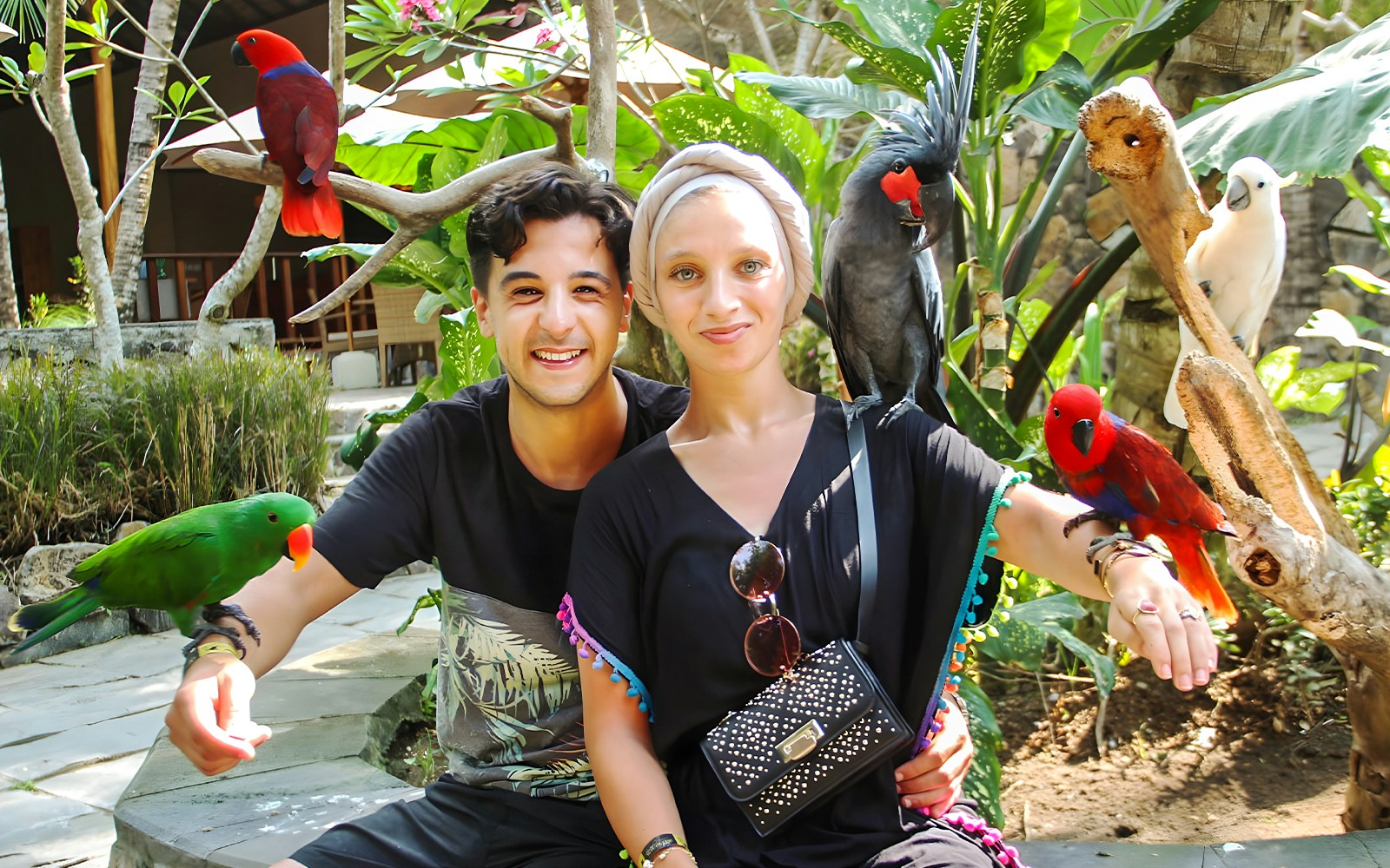 Visitors interacting with colorful parrots at Lombok Wildlife Park.