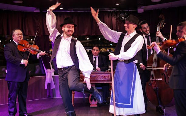 Budapest dinner cruise with folk dancers and musicians performing on stage.