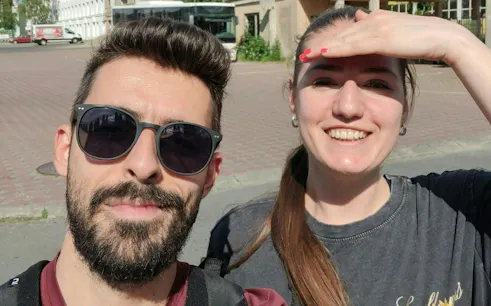 Two people smiling during a self-guided city exploration in Brașov.
