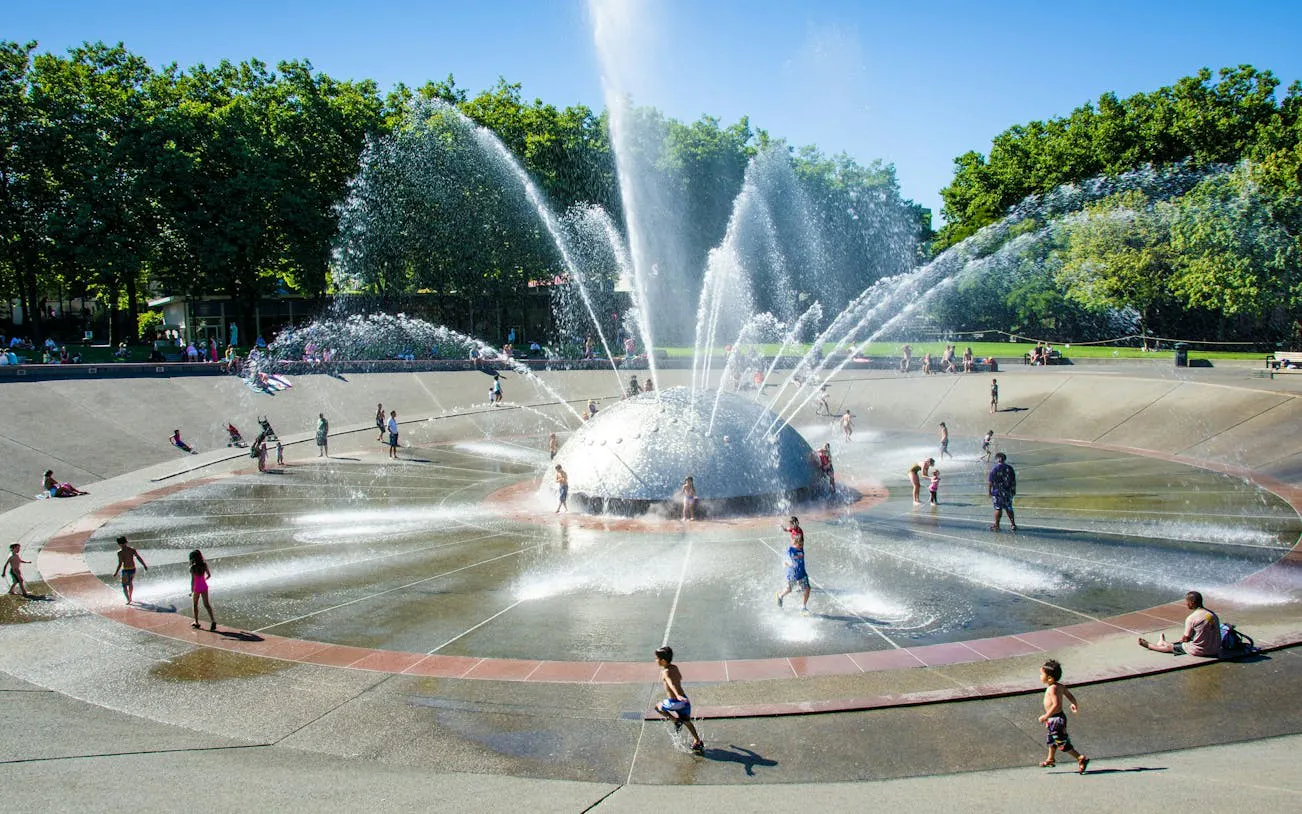 Children playing at the International Fountain in Seattle Center on a sunny day.