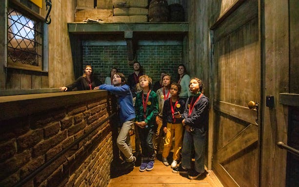 Children using audio guides at Historium Brugge, Belgium, exploring interactive exhibits.
