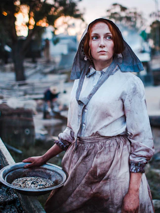 Woman in period costume panning for gold at Sovereign Hill, Australia.