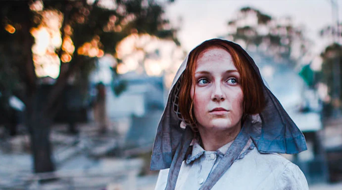 Woman in period costume panning for gold at Sovereign Hill, Australia.