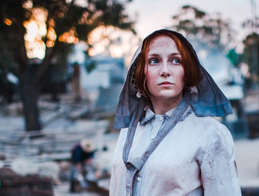 Woman in period costume panning for gold at Sovereign Hill, Australia.