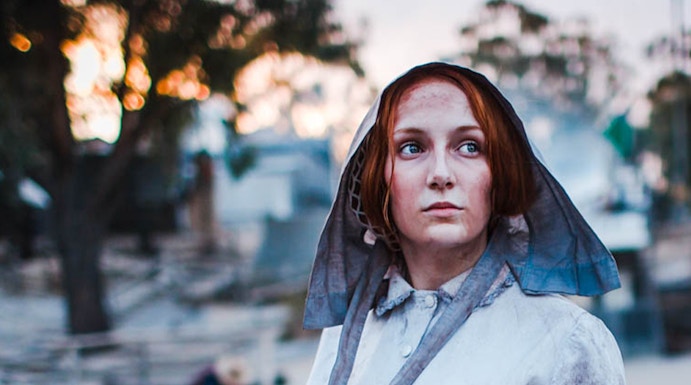 Woman in period costume panning for gold at Sovereign Hill, Australia.