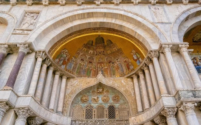 St. Mark’s Basilica ornate facade with detailed mosaics and marble columns in Venice, Italy.