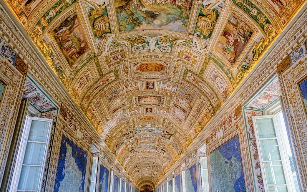 Vatican Museums' ornate hallway ceiling with detailed frescoes and maps.