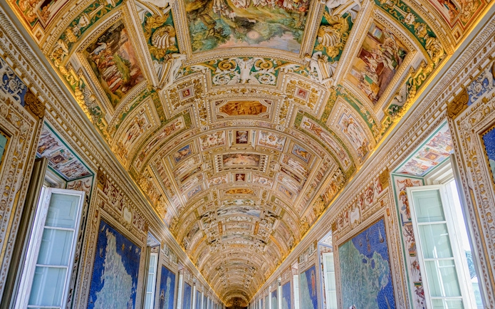 Vatican Museums' ornate hallway ceiling with detailed frescoes and maps.