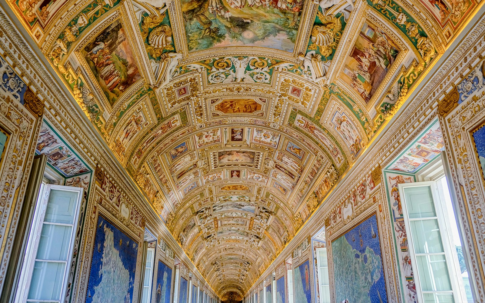 Vatican Museums' ornate hallway ceiling with detailed frescoes and maps.