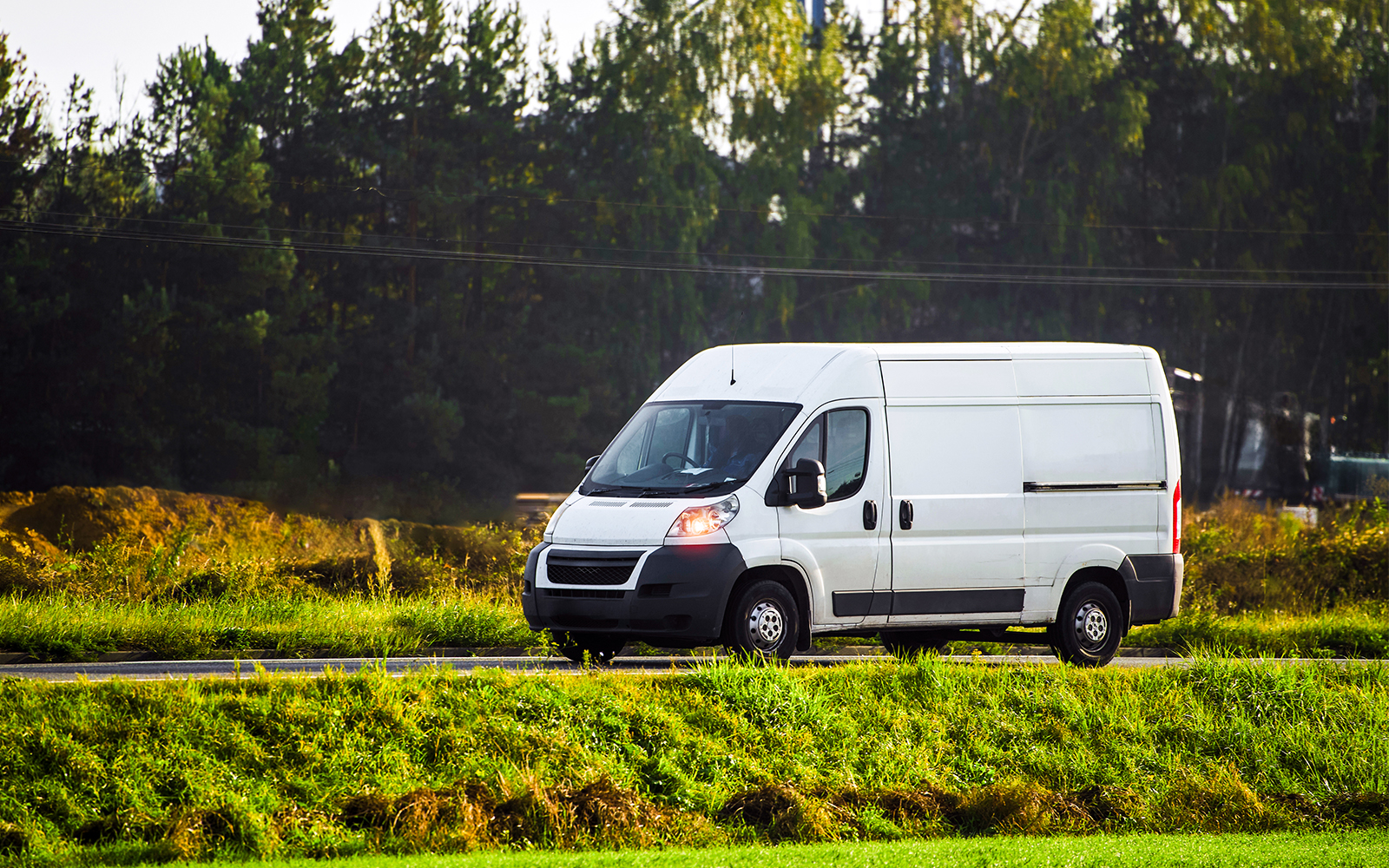 Mini bus parked near scenic mountain road in Switzerland.
